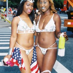 Two women in American-flag bikinis at parade