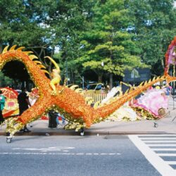 Golden dragon parade float on city street