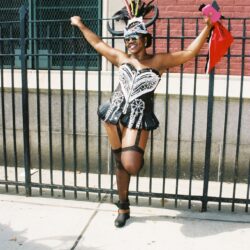 Masked person in feathered carnival costume dancing