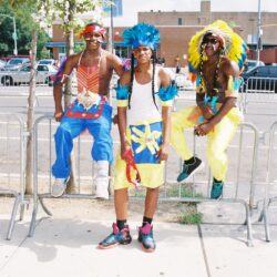 Three people in bright carnival costumes