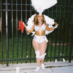 Smiling carnival dancer in white feathered costume