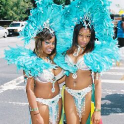 Two women in turquoise feathered carnival costumes