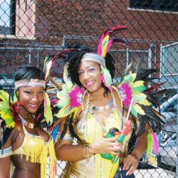 Two carnival performers in colorful feathered costumes