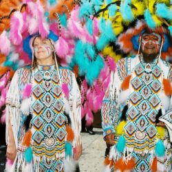 Two people in colorful feathered carnival costumes