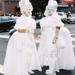 Two people in white Victorian-style parade costumes