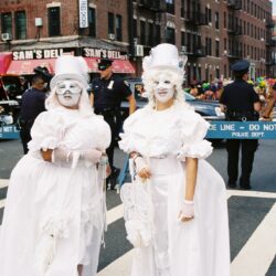 Two performers in white costumes at parade