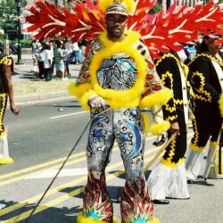 Man in colorful feathered carnival costume marching