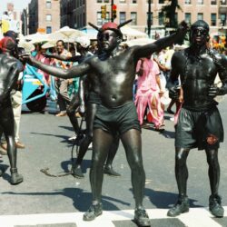 Parade performers covered in black body paint