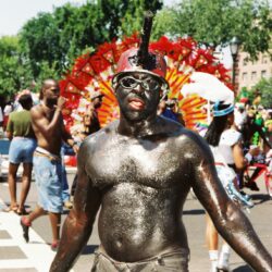 Parade participant covered in black body paint