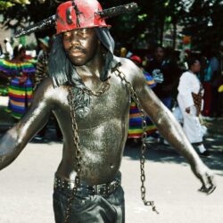Parade participant in metallic body paint with chains