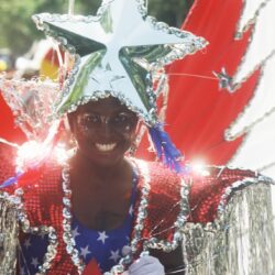 Smiling person in star-themed red, white, blue costume