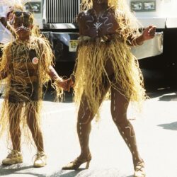Two dancers wearing straw skirts and body paint