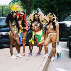 Four women in colorful carnival costumes on street