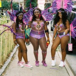 Three women in purple feathered carnival costumes