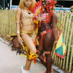 Two women in bright feathered carnival costumes