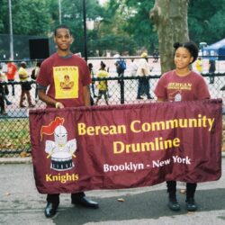 Two youths holding Berean Community Drumline banner