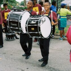Two smiling marching band bass drummers