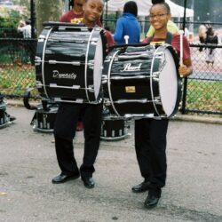 Two smiling marching band bass drummers