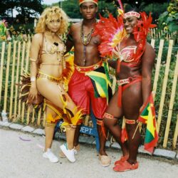 Three people in vibrant carnival costumes