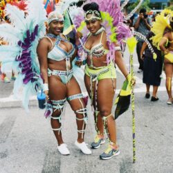 Two women in colorful feathered carnival costumes