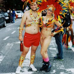 Couple in colorful feathered costumes at carnival parade
