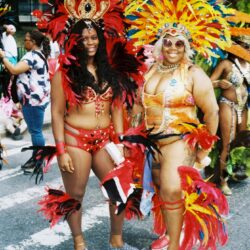 Two women in colorful feathered carnival costumes