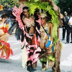 Two women in vibrant feathered carnival costumes