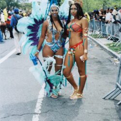 Two women in colorful carnival feathered costumes
