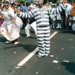 Man in striped costume dancing at street parade