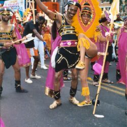Carnival dancers in bright yellow and purple costumes