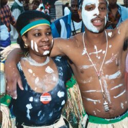 Carnival couple with white body paint and skirts