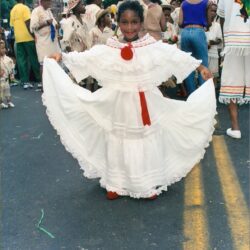 Girl in white dress holding skirt at parade