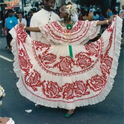 Woman in red embroidered folkloric dress dancing