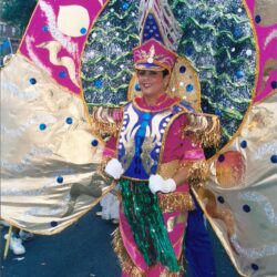 Person in vibrant pink and gold carnival costume