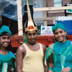 Three smiling people in carnival costumes