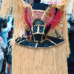 Elaborate straw carnival mask with pink accents