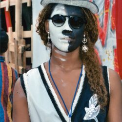Person wearing half black-and-white face paint, top hat