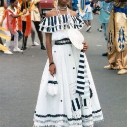 Woman in white striped festival dress holding fan