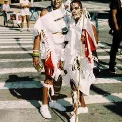 Two people in white costumes with painted faces