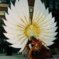Performer with giant white and gold wings