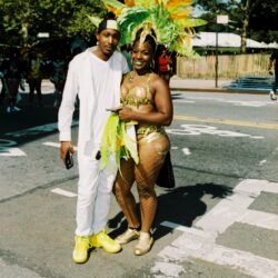 Couple at street carnival, woman in feathered headdress