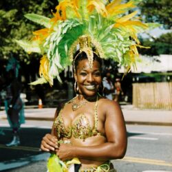 Smiling woman with green and yellow carnival headdress