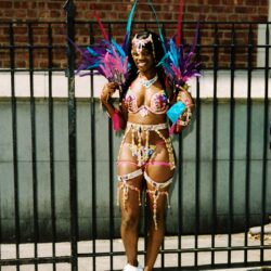 Smiling woman in colorful feathered carnival costume