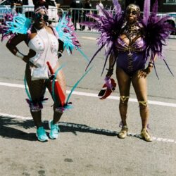 Two people in colorful feathered carnival costumes