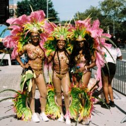 Three dancers in vibrant pink-green carnival costumes
