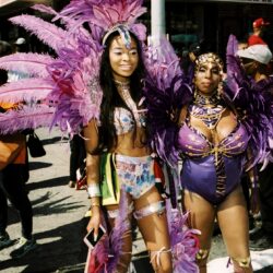 Two women in purple feathered carnival costumes