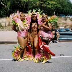 Three people in pink feathered carnival costumes