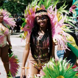Smiling carnival dancer in colorful feathered costume