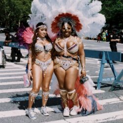 Two women in colorful feathered carnival costumes