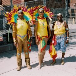 Three people in vibrant carnival costumes